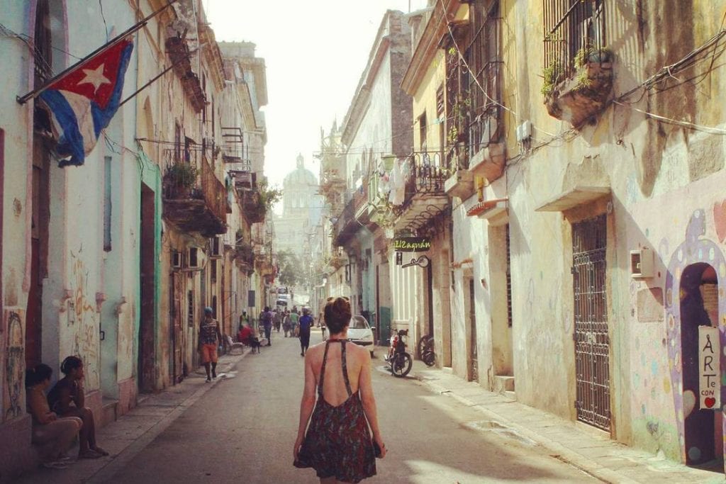 a girl walking down a street in havana cuba