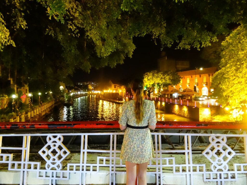 lady at bridge in melacca at night
