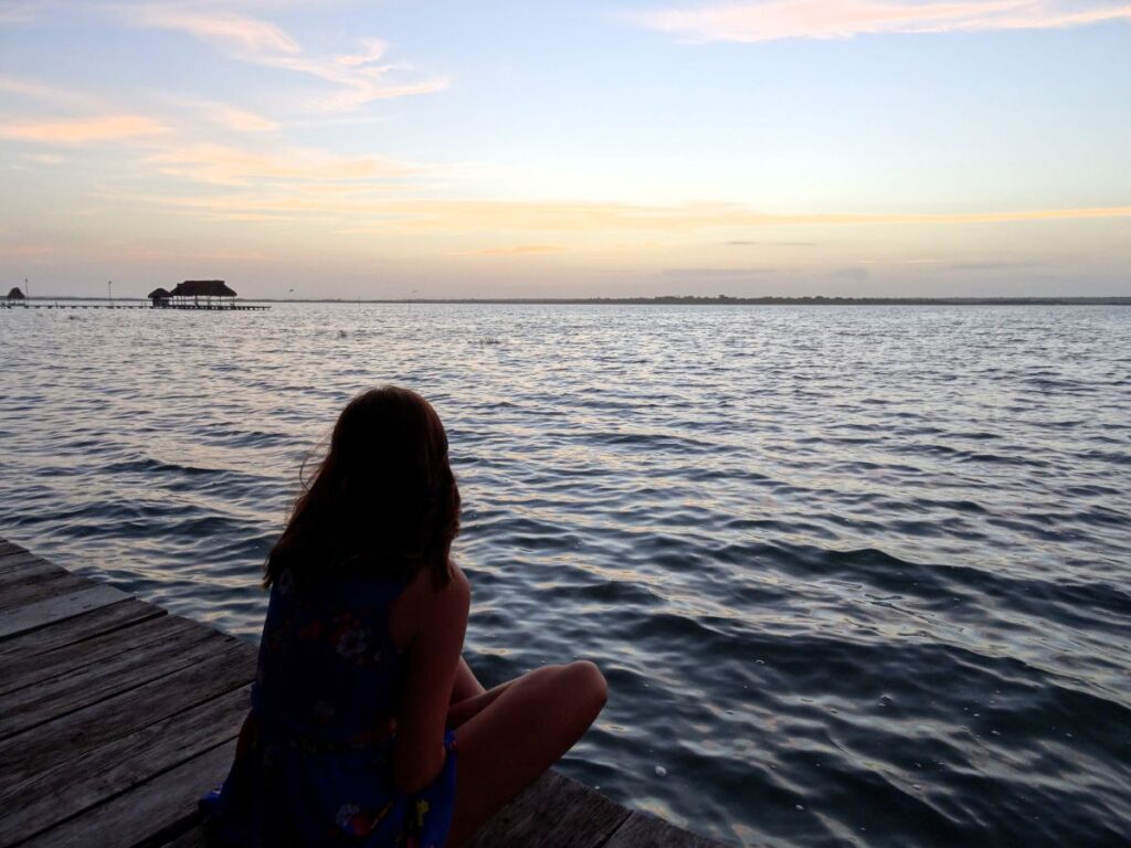 lady watching sunset laguna bacalar